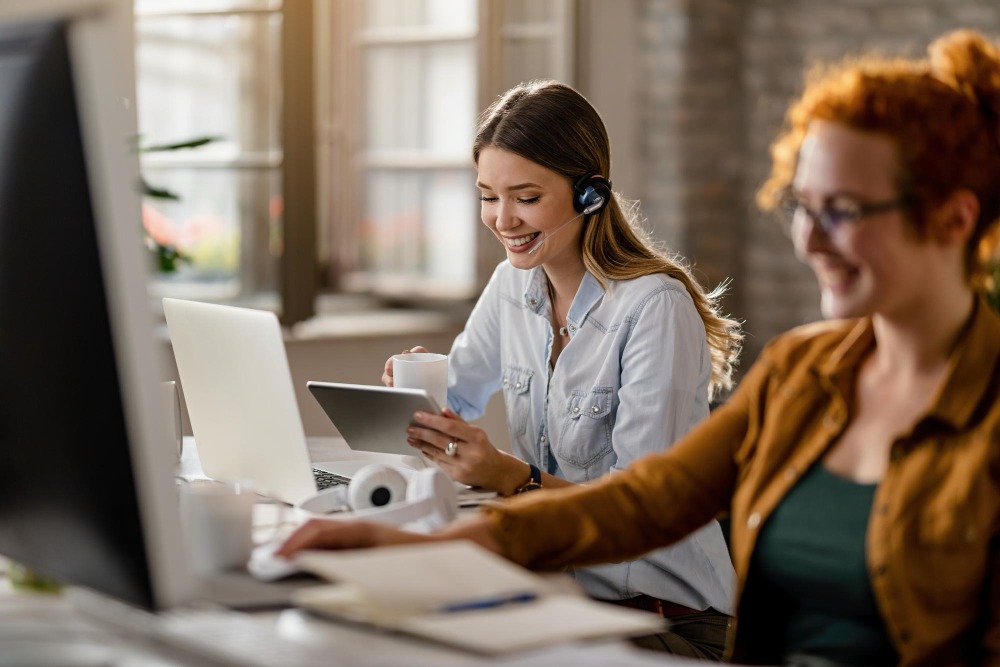 Two women sitting at laptop customer support agents